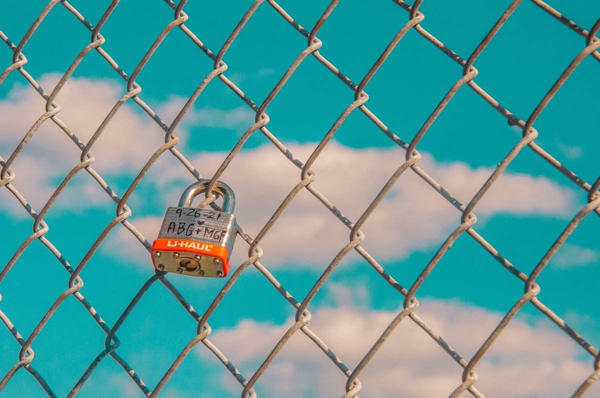 a padlock attached to a chain link fence