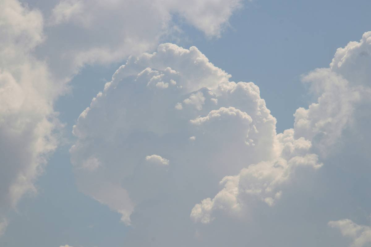 A plane flying in the sky with a lot of clouds