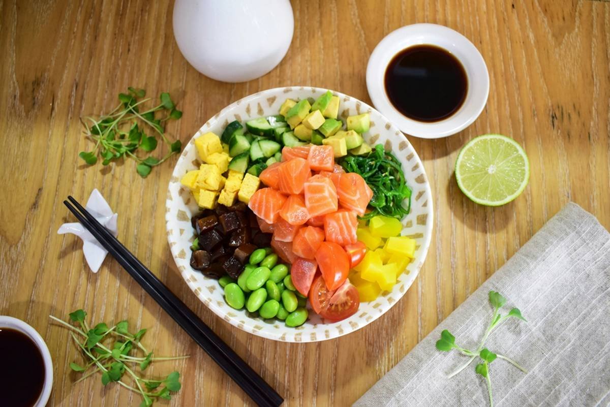 Top view of a salmon and avocado poke bowl, showcasing fresh ingredients, natural colors, and a clean, balanced composition.